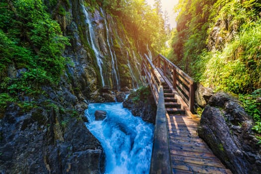 Beautiful Wimbachklamm gorge with wooden path in autumn colors, Ramsau bei Berchtesgaden in Germany. Waterfall at Wimbachklamm near Ramsau-Berchtesgaden, Bavaria, Germany.