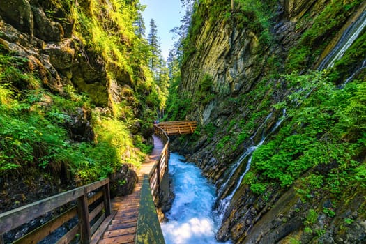 Beautiful Wimbachklamm gorge with wooden path in autumn colors, Ramsau bei Berchtesgaden in Germany. Waterfall at Wimbachklamm near Ramsau-Berchtesgaden, Bavaria, Germany.