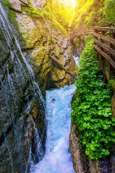 Beautiful Wimbachklamm gorge with wooden path in autumn colors, Ramsau bei Berchtesgaden in Germany. Waterfall at Wimbachklamm near Ramsau-Berchtesgaden, Bavaria, Germany.