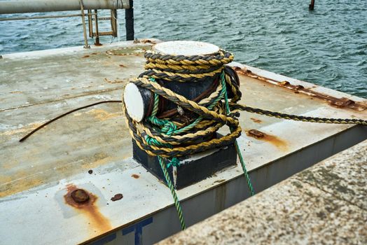 The cross shaped mooring bitt has mooring line wrapped around it to anchor a ship in while in port.