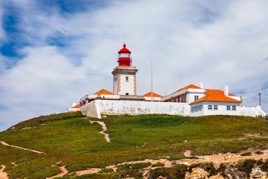 The lighthouse in Cabo da Roca. Cliffs and rocks on the Atlantic ocean coast in Sintra in a beautiful summer day, Portugal. Cabo da Roca, Portugal. Lighthouse and cliffs over Atlantic Ocean.