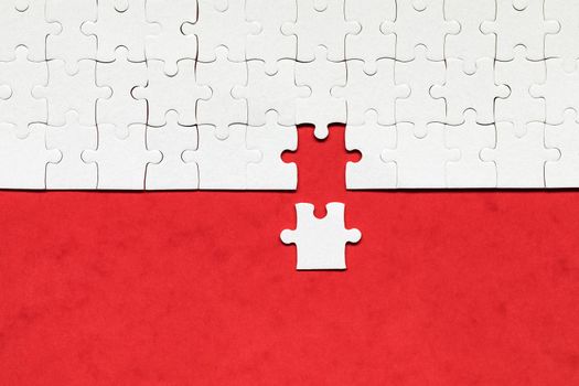 White jigsaw puzzle. White puzzle pieces on color background. Unfinished white jigsaw puzzle pieces on color background. 