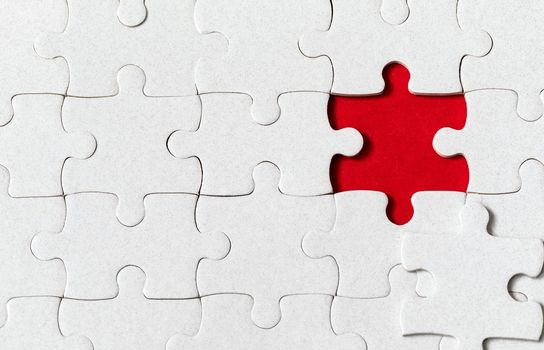 White jigsaw puzzle. White puzzle pieces on color background. Unfinished white jigsaw puzzle pieces on color background. 