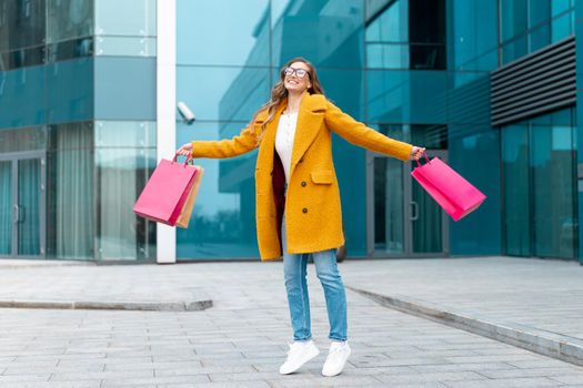 Business Woman With Shopping Bags Dressed Yellow Coat Jumping With Happiness Outdoors Corporative Building Caucasian Female Business Person Near Office Building Stylish Businesswoman Season Sale