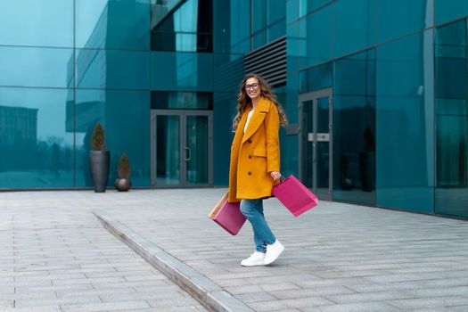 Business Woman With Shopping Bags Dressed Yellow Coat Walking Outdoors Corporative Building Background Caucasian Female Business Person Office Building Stylish Businesswoman Season Sale full length