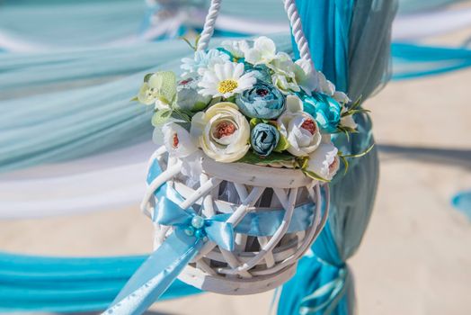 Setup of wedding day marriage aisle with drapes and flower bouquet on sandy tropical beach paradise