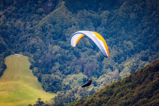 Paragliding in paradise landscape with volcano crater and lagoon in Azores. Paraglider above Lagoa das Furnas, Sao Miguel, Azores, Portugal, Europe