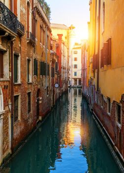 Street canal in Venice, Italy. Narrow canal among old colorful brick houses in Venice, Italy. Venice postcard