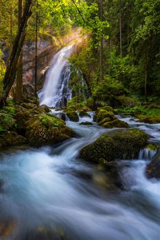 Gollinger Waterfall in Golling an der Salzach near Salzburg, Austria. Gollinger Wasserfall with mossy rocks and green trees, Golling, Salzburger Land, Austria.