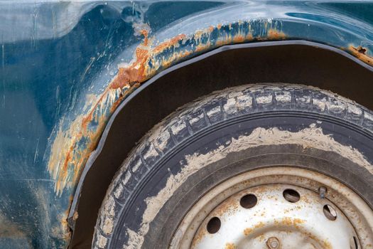 rusted off-road vehicle, close-up view on wing and wheel arch with heavy rust and scratches