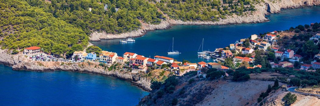 Assos village in Kefalonia, Greece. Turquoise colored bay in Mediterranean sea with beautiful colorful houses in Assos village in Kefalonia, Greece, Ionian island, Cephalonia, Assos village.