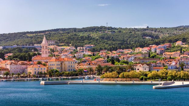 Supetar city in Brac island, Croatia. View from the sea. Picturesque scenic view on Supetar on Brac island, Croatia. Panoramic view on harbor of town Supetar from the side of sea. Brac, Croatia.