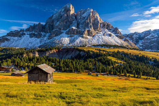 Stunning view of Peitlerkofel mountain from Passo delle Erbe in Dolomites, Italy. View of Sass de Putia (Peitlerkofel) at Passo delle Erbe, with wooden farm houses, Dolomites, South Tyrol, Italy.