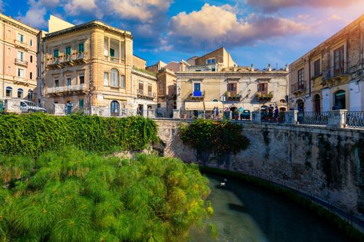 The Fountain of Arethusa and Siracusa (Syracuse) in a sunny summer day. Sicily, Italy. The Fountain of Arethusa in Ortygia, historical centre of Syracuse, Sicily, Italy.