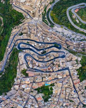 Aerial view of the old town of Ragusa Ibla and a winding road. View from above of the city in Ragusa Ibla, Province of Ragusa, Val di Noto, Sicily, Italy. 