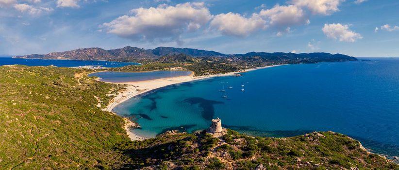 Torre di Porto Giunco Tower and Simius Beach near Villasimius, Sardinia, Italy. View from flying drone. Torre di Porto Giunco tower on Carbonara cape. Aerial morning view of Sardinia island, Italy