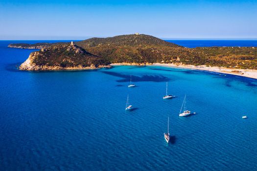 Torre di Porto Giunco Tower and Simius Beach near Villasimius, Sardinia, Italy. View from flying drone. Torre di Porto Giunco tower on Carbonara cape. Aerial morning view of Sardinia island, Italy