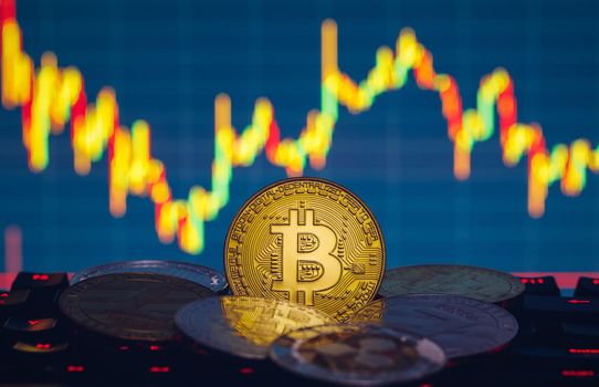 Bitcoin, litecoin and ripple coins currency finance money on graph chart background. Bitcoin as most important cryptocurrency concept. Stack of cryptocurrencies with a golden bitcoin in the middle.