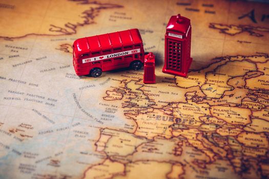 The iconic red bus and Big Ben miniature with compass on the map of London, UK. Concept of travel.