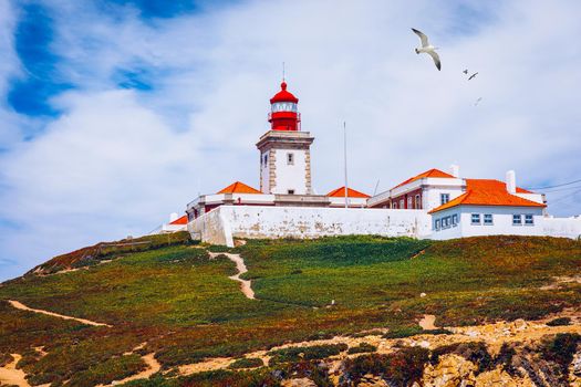 The lighthouse in Cabo da Roca. Cliffs and rocks on the Atlantic ocean coast in Sintra in a beautiful summer day, Portugal. Cabo da Roca, Portugal. Lighthouse and cliffs over Atlantic Ocean.