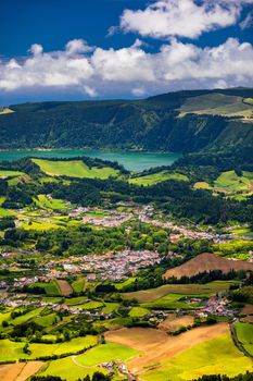 View of Furnas town and lake (Lagoa das Furnas) on Sao Miguel Island, Azores, Portugal from the Miradouro do Salto do Cavalo viewpoint. A tranquil scene of lush foliage and town in a volcanic crater