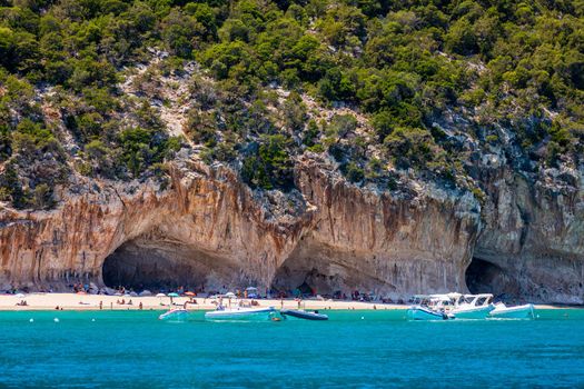 Blue sea and the characteristic caves of Cala Luna, a beach in the Golfo di Orosei, Sardinia, Italy. Big sea caves in the mediterranean coast. Sardinia, Italy.