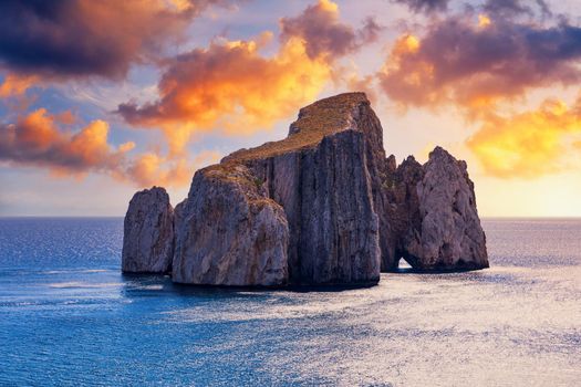 High cliffs of Mediterranean coast, "Pan di Zucchero" stack rock in Masua, west coast of Sardinia, Italy. Concali su terrainu a limestone formation in southern Sardinia, Italy.
