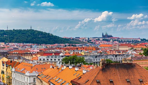 View of Prague Castle over red roof from Vysehrad area at sunset lights, Prague, Czech Republic. Scenic view of Prague city, Prague castle and Petrin tower from Vysehrad overlooking red roofs 