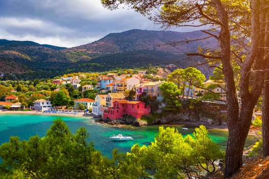 Turquoise colored bay in Mediterranean sea with beautiful colorful houses in Assos village in Kefalonia, Greece. Town of Assos with colorful houses on the mediterranean sea, Greece. 