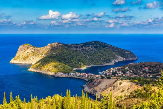 Turquoise colored bay in Mediterranean sea with beautiful colorful houses in Assos village in Kefalonia, Greece. Town of Assos with colorful houses on the mediterranean sea, Greece. 