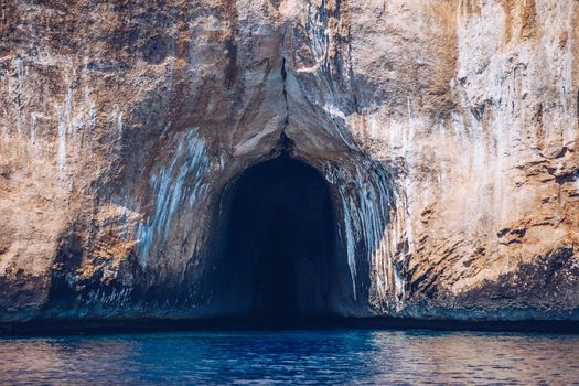 Blue sea and the characteristic caves of Cala Luna, a beach in the Golfo di Orosei, Sardinia, Italy. Big sea caves in the mediterranean coast. Sardinia, Italy.