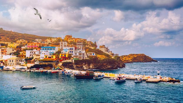 Panorama of Harbour with vessels, boats, beach and lighthouse in Bali at sunrise, Rethymno, Crete, Greece. Famous summer resort in Bali village, near Rethimno, Crete, Greece. 