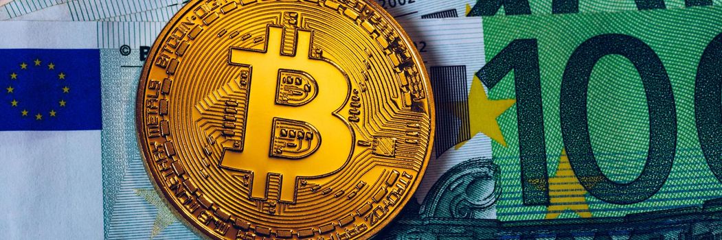 Golden bitcoin over Euro money. Bitcoin cryptocurrency. Crypto currency concept. Bitcoin with euro bills. Bitcoins stacked on euro banknotes.