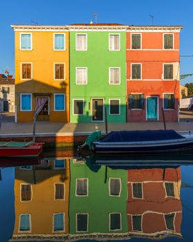 Street with colorful buildings in Burano island, Venice, Italy. Architecture and landmarks of Burano, Venice postcard. Scenic canal and colorful architecture in Burano island near Venice, Italy