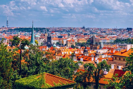 Prague red roofs and dozen spires of historical Old Town of Prague. Cityscape of Prague on a sunny day. Red rooftops, spires and the Charles Bridge and Vltava River in the background. Prague, Czechia.