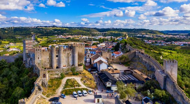 Aerial view of the historic walled town of Obidos at sunset, near Lisbon, Portugal. Aerial shot of Obidos Medieval Town, Portugal. Aerial view of medieval fortress in Obidos. Portugal.