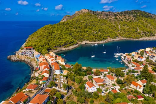 Aerial drone view video of beautiful and picturesque colorful traditional fishing village of Assos in island of Cefalonia, Ionian, Greece. Peninsula of Assos in Cephalonia (Kefalonia), Greece