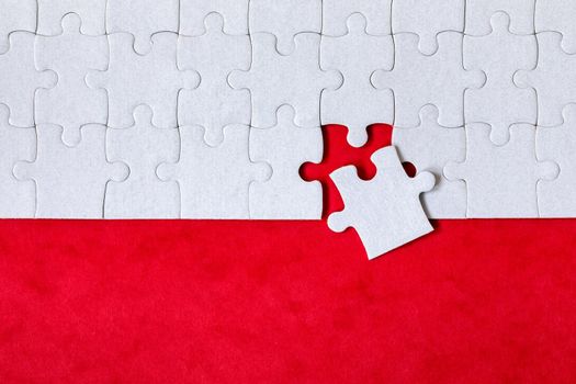White jigsaw puzzle. White puzzle pieces on color background. Unfinished white jigsaw puzzle pieces on color background. 