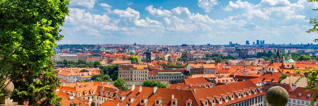 Prague red roofs and dozen spires of historical Old Town of Prague. Cityscape of Prague on a sunny day. Red rooftops, spires and the Charles Bridge and Vltava River in the background. Prague, Czechia.