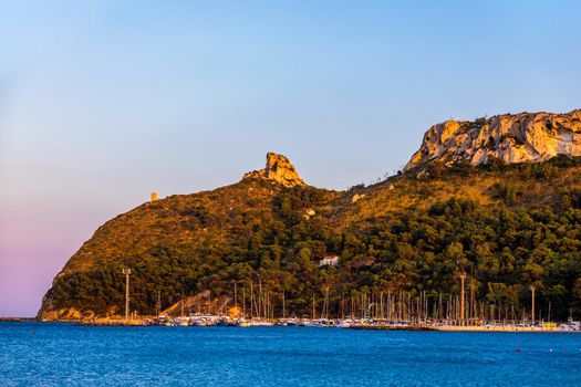 Beach of Cagliari (Poetto Sella del Diavolo) with Torre del Poetto tower and boats at sunset, Sardinia, Italy. 