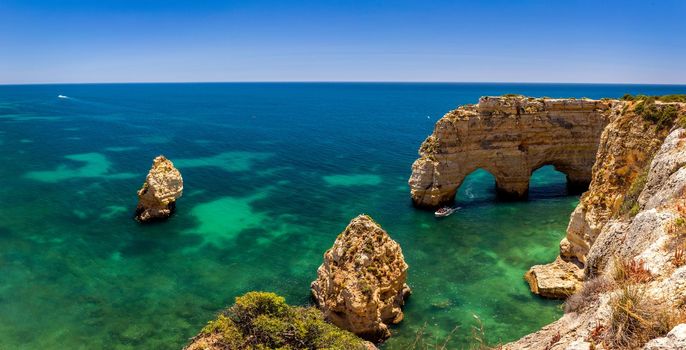 Natural caves at Marinha beach, Algarve Portugal. Rock cliff arches on Marinha beach and turquoise sea water on coast of Portugal in Algarve region. 