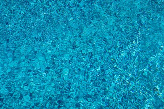 Blue ripped water in swimming pool. Surface of blue swimming pool, background of water in swimming pool. Water swimming pool texture and surface water on pool. Blue ripped water in swimming pool.