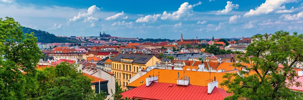 View of Prague Castle over red roof from Vysehrad area at sunset lights, Prague, Czech Republic. Scenic view of Prague city, Prague castle and Petrin tower from Vysehrad overlooking red roofs 