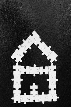 House made of puzzles. Modern house puzzle white pieces for concept design. Jigsaw Home, building, exterior. Puzzle construction renting, leasing, mortgage. House is made up of pieces of puzzles.
