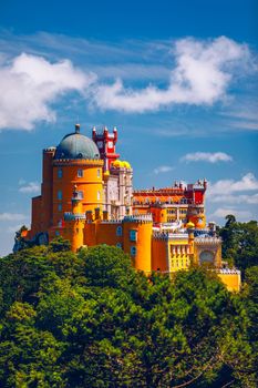 Famous historic Pena palace part of cultural site of Sintra against sunset sky in Portugal. Panoramic View Of Pena Palace, Sintra, Portugal. Pena National Palace at sunset, Sintra, Portugal. 