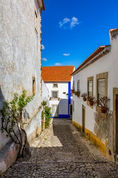 Historic walled town of Obidos, near Lisbon, Portugal. Beautiful streets of Obidos Medieval Town, Portugal. Street view of medieval fortress in Obidos. Portugal.