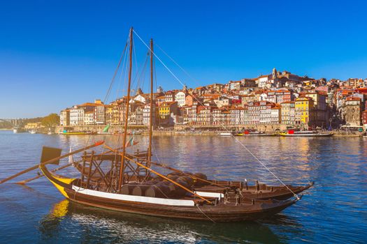 Port wine boats at the waterfront with the old town on the Douro River in Ribeira in the city centre of Porto in Porugal, Europe. Portugal, Porto