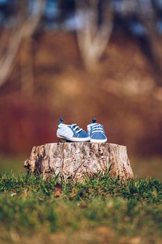 Young couple waiting for baby. Expecting parents with little baby boy shoes. Concept of Parents-To-Be. Shoes and sneakers of parents and expected baby. Mom, dad and the future baby Shoes.