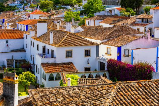 Historic walled town of Obidos, near Lisbon, Portugal. Beautiful streets of Obidos Medieval Town, Portugal. Street view of medieval fortress in Obidos. Portugal.