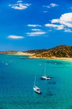 Aerial view of anchored sailing yacht in emerald sea. Aerial view of a boat. Outdoor water sports, yachting. Aerial view of anchoring yacht in open water. Ocean and sea travel and transportation